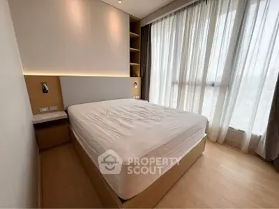 Modern bedroom with large windows and built-in storage in a stylish apartment.