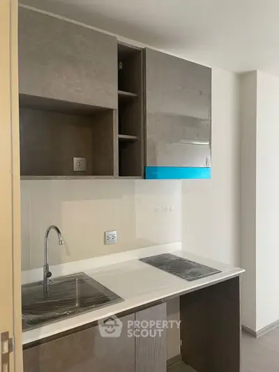 Modern compact kitchen with sleek cabinetry and built-in stovetop