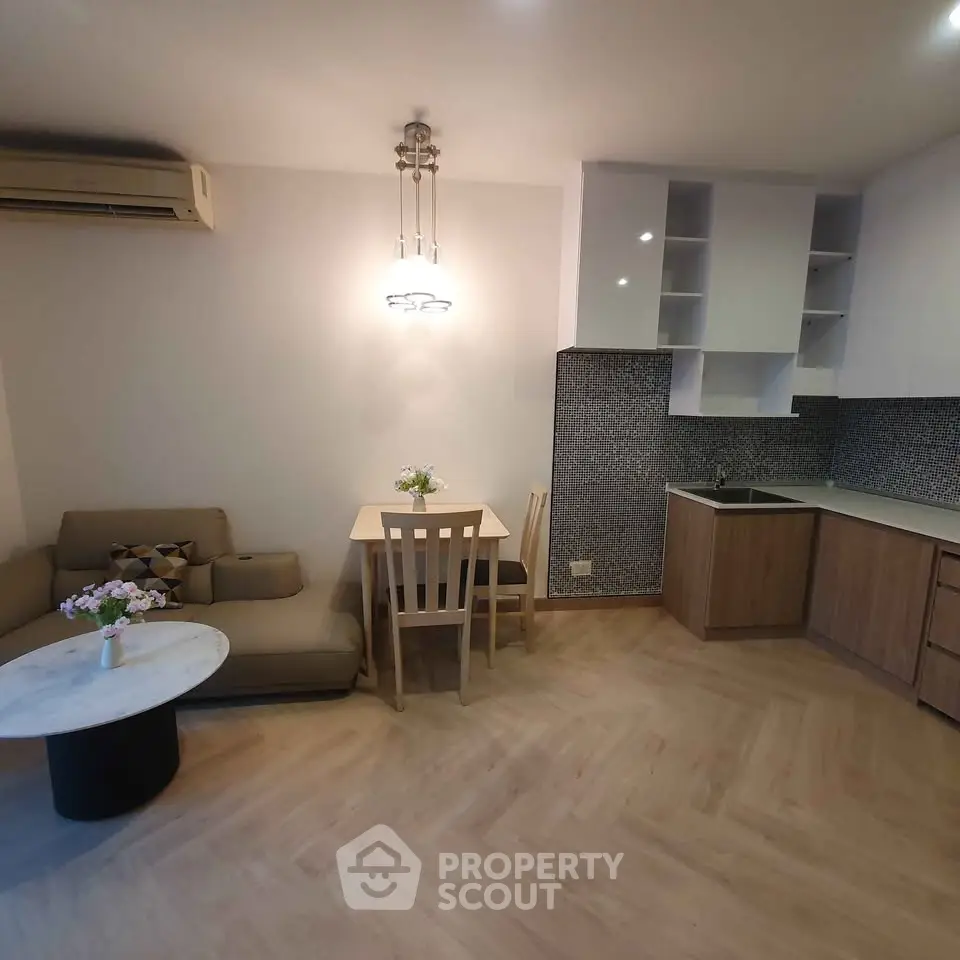 Cozy living room with modern kitchen and elegant lighting