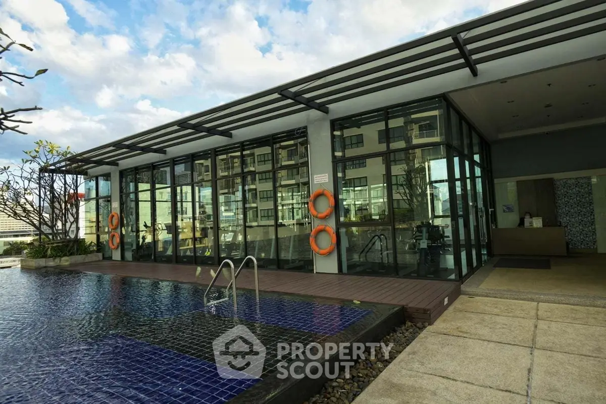 Modern building with pool and glass facade, perfect for luxury living.