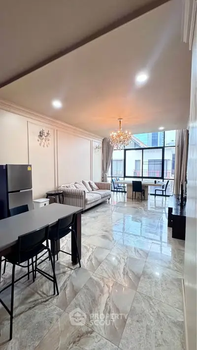 Spacious modern living room with elegant chandelier and marble flooring