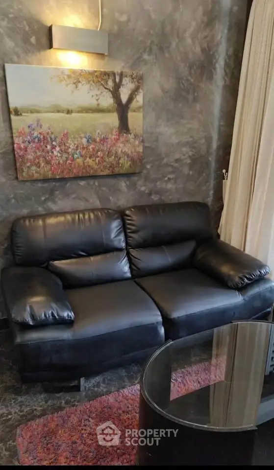 Stylish living room with black leather sofa and elegant wall art