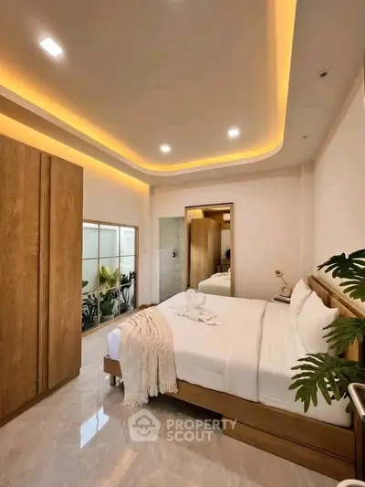 Luxurious bedroom with modern lighting and elegant decor, featuring a cozy bed and stylish wooden wardrobe.