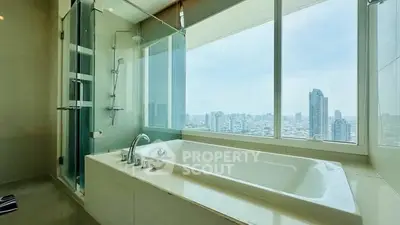 Luxurious bathroom with city view and modern bathtub in high-rise apartment.