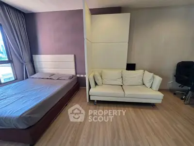 Modern bedroom with stylish decor and cozy seating area, perfect for relaxation and comfort.