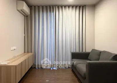 Cozy living room with modern sofa and air conditioning, perfect for relaxation.