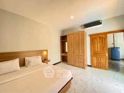 Spacious bedroom with wooden furniture and modern air conditioning unit.