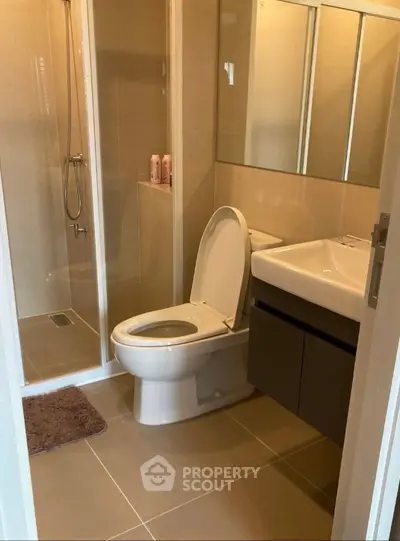 Modern bathroom with sleek fixtures and glass shower enclosure in a contemporary apartment.