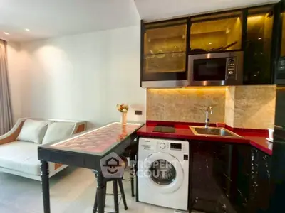 Modern kitchen with red countertop, washing machine, and microwave in stylish apartment.