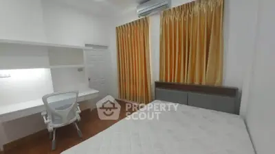 Modern bedroom with study area, featuring a comfortable bed and sleek desk setup.