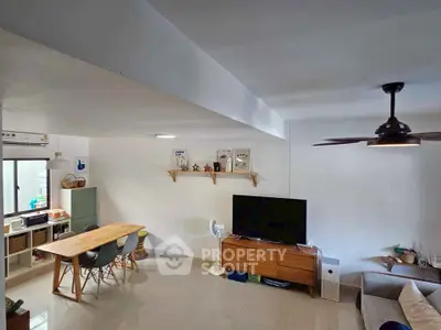 Modern living room with sleek furniture and open layout, featuring a dining area and stylish decor.