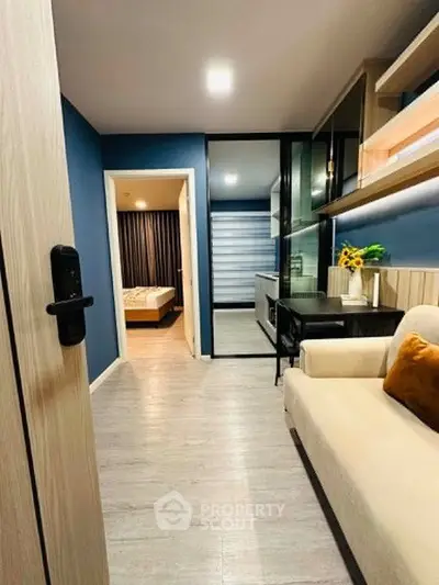 Modern apartment interior with cozy living room and view into bedroom, featuring stylish decor and open layout.