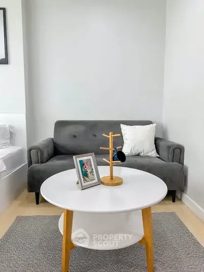Chic modern living room with stylish gray sofa and elegant round coffee table, perfect for cozy relaxation.