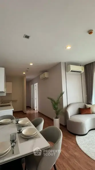 Modern living room with dining area and air conditioning in a stylish apartment.