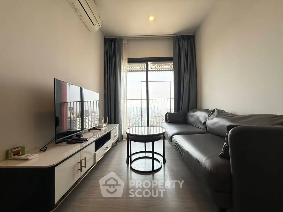 Modern living room with sleek furniture and city view balcony in high-rise apartment.