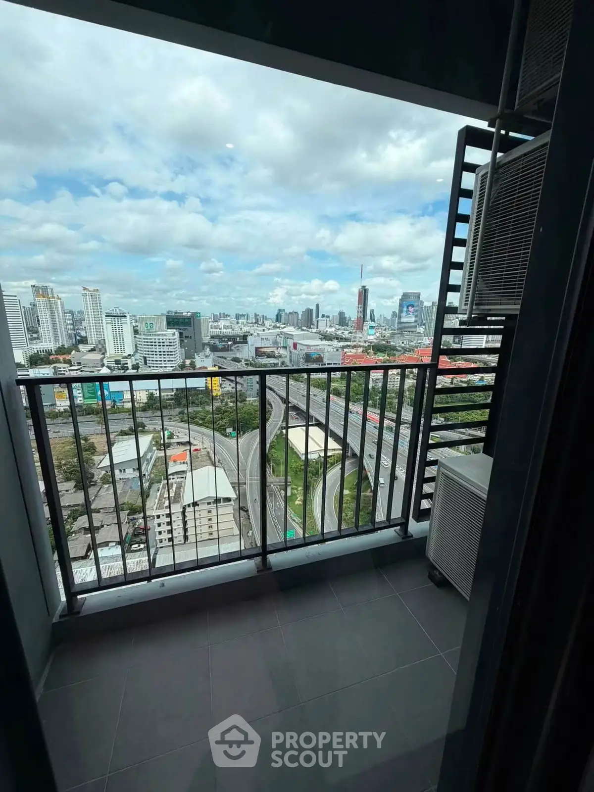 Stunning cityscape view from a high-rise balcony with modern railing and urban skyline.