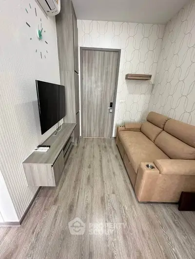 Modern living room with sleek design, featuring a wall-mounted TV and comfortable sofa.