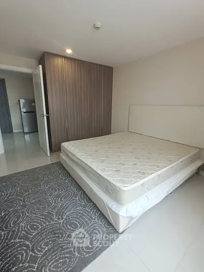 Spacious bedroom with modern wardrobe and comfortable mattress in a stylish apartment.