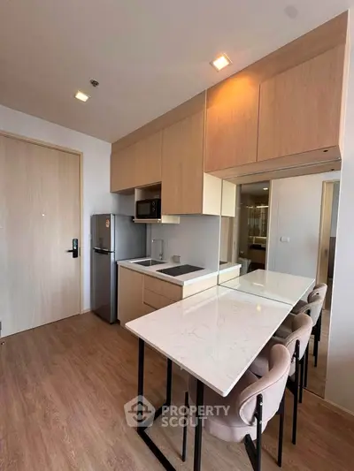 Modern kitchen with sleek design, featuring a marble countertop and integrated appliances.