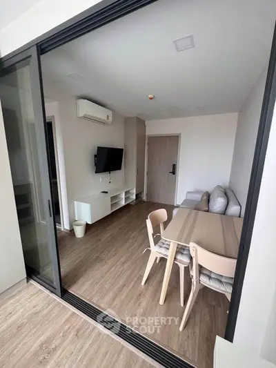 Modern living room with sleek furniture and wooden flooring in a stylish apartment.