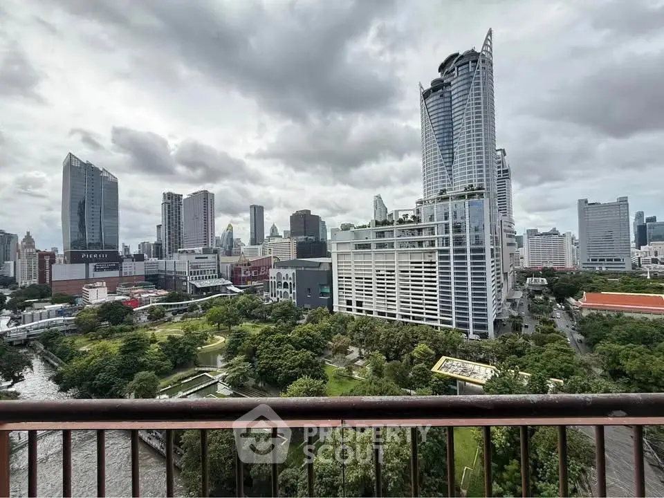 Stunning cityscape view from a high-rise balcony overlooking lush greenery and modern skyscrapers.
