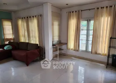 Spacious living room with large windows and natural light, perfect for relaxation and entertaining.