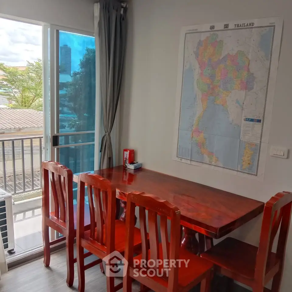 Charming dining area with wooden table and chairs, large map wall decor, and balcony view.
