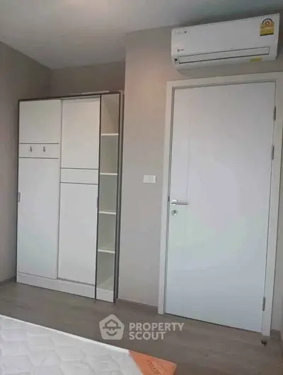 Modern bedroom with sleek wardrobe and air conditioning unit