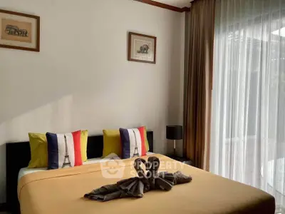 Cozy bedroom with elegant decor and large window offering natural light.
