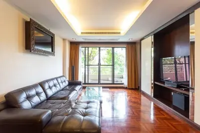 Spacious living room with leather sofa and large window balcony view