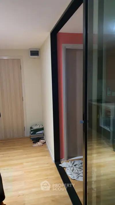 Modern apartment entrance with wooden flooring and glass partition