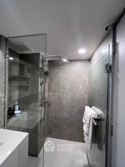 Modern bathroom with sleek glass shower and elegant marble tiles