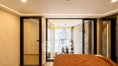 Modern bedroom with large windows and city view, featuring stylish decor and cozy ambiance.