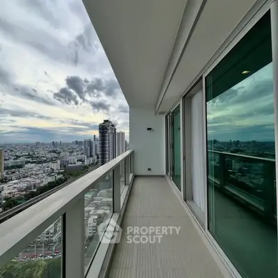 Stunning high-rise balcony with panoramic city views and modern glass railing.