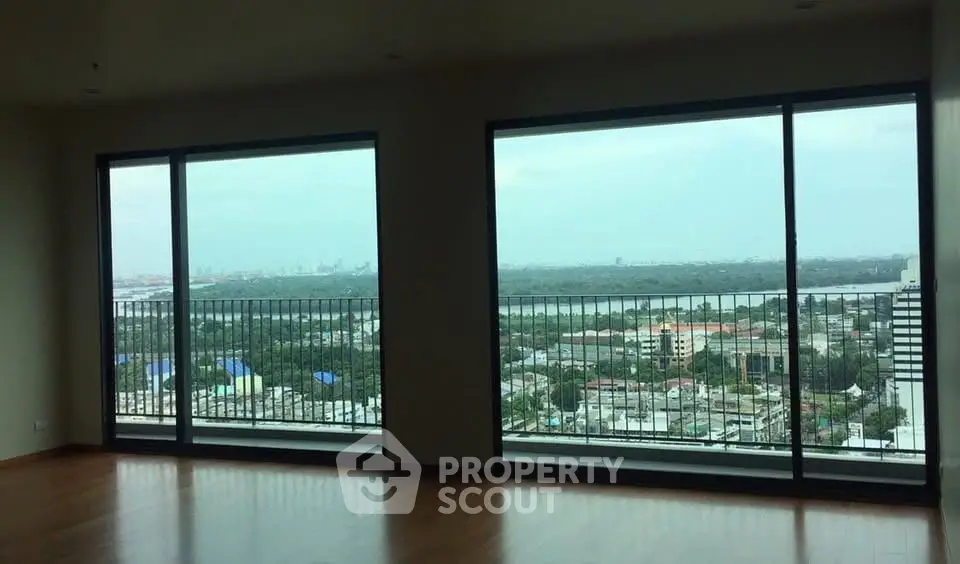 Spacious living room with panoramic city view through large windows.