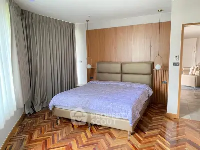 Spacious bedroom with elegant parquet flooring and modern decor