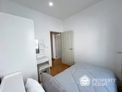 Cozy bedroom with ample natural light, featuring a comfortable bed, built-in wardrobe, and a clean, minimalist design perfect for rest and relaxation.