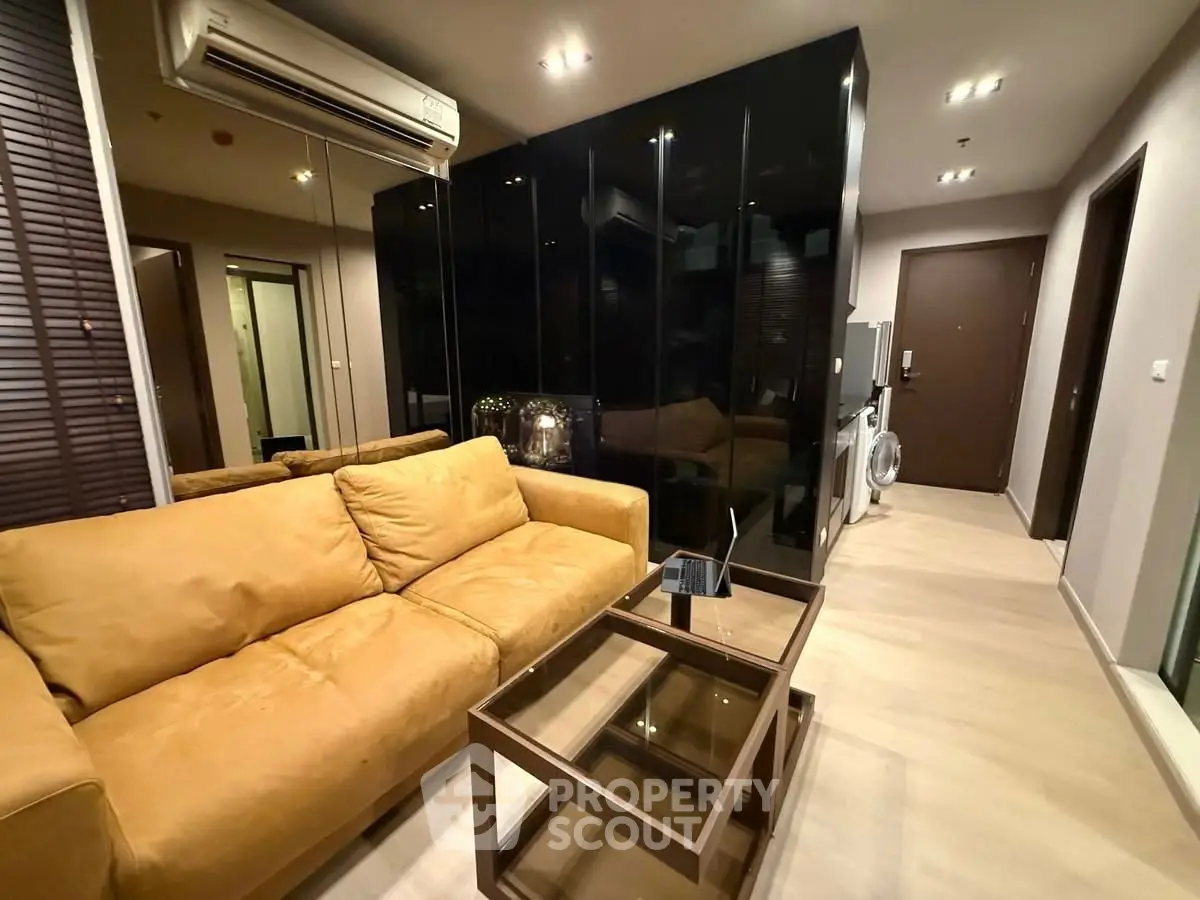 Modern living room with sleek black cabinets and cozy beige sofa