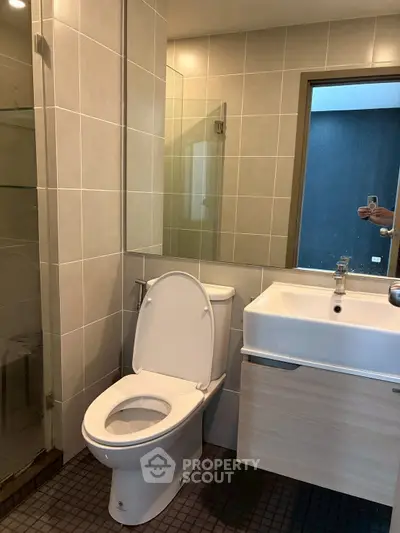 Modern bathroom with glass shower and sleek fixtures in contemporary apartment.