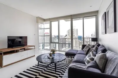 Modern living room with city view, stylish furniture, and natural light.
