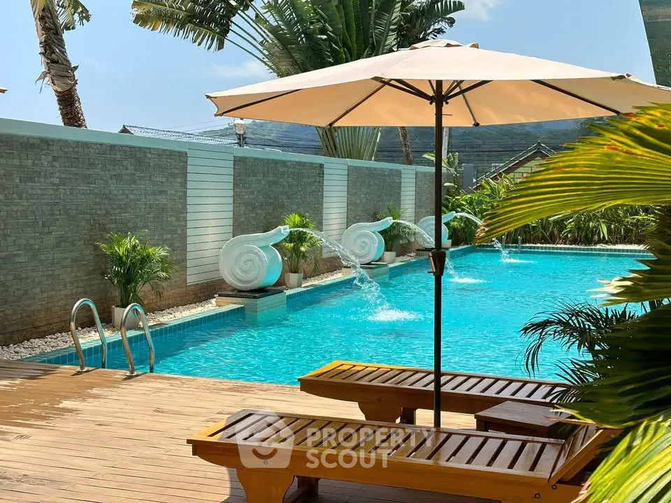 Luxurious outdoor pool area with sun loungers and elegant water features.