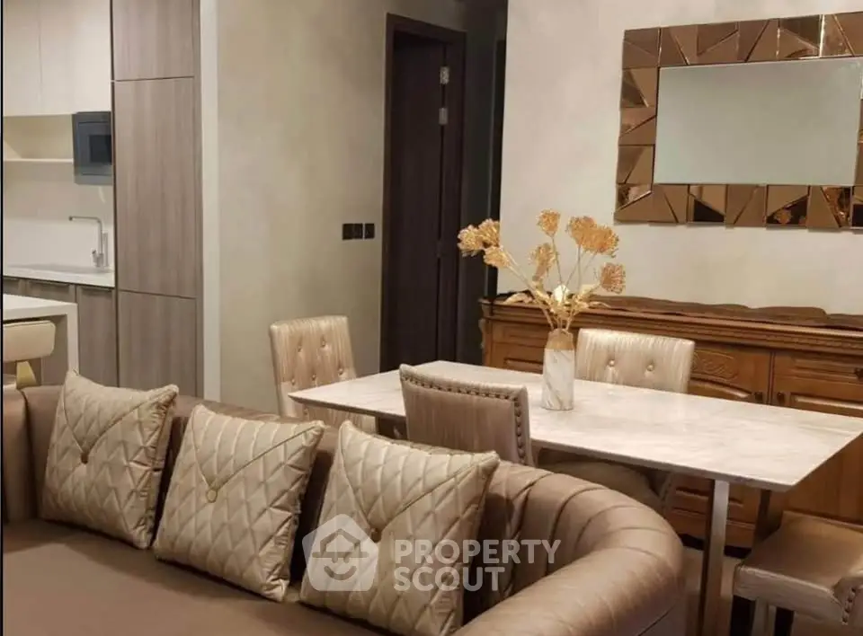 Elegant living room with modern decor and stylish furniture, featuring a plush sofa and chic dining area.