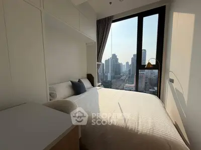 Modern bedroom with city view, large window, and cozy decor in urban apartment.