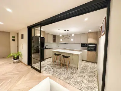 Modern open-layout kitchen with island and stylish lighting in a contemporary apartment.