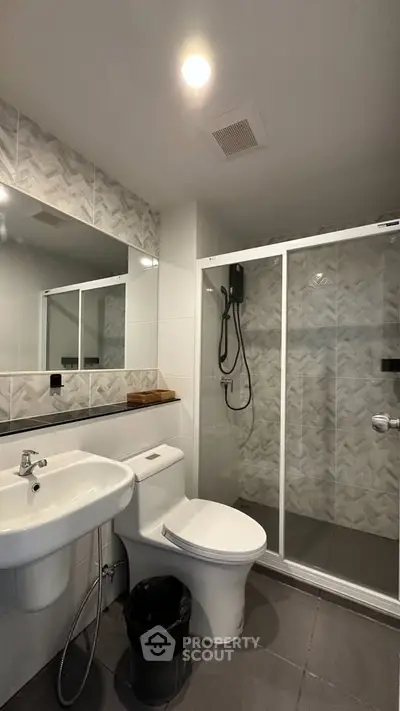 Modern bathroom with sleek shower and stylish tiles in contemporary apartment.