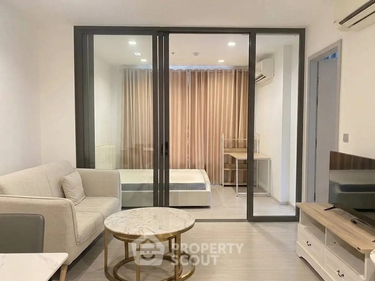 Modern studio apartment with glass partition, cozy living area, and stylish furnishings.