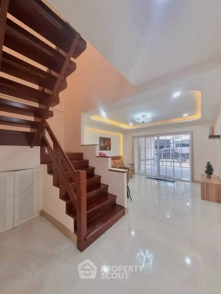 Spacious modern living room with elegant wooden staircase and bright lighting