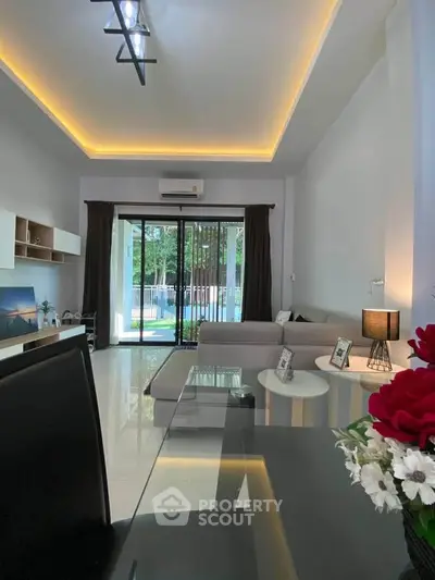 Modern living room with large windows and stylish decor, featuring a spacious layout and natural light.