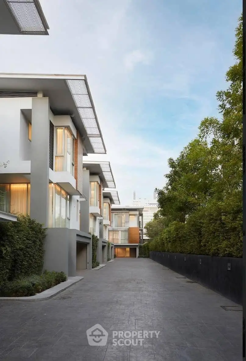 Modern townhouse complex with sleek design and lush greenery, offering a serene and upscale living environment.