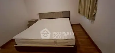 Spacious bedroom with a large bed and wooden flooring, perfect for relaxation.